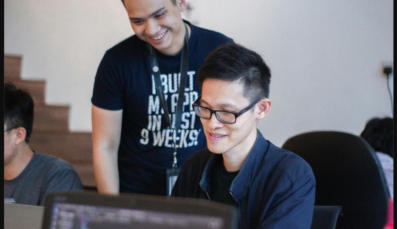 A mentor helping a participant at his computer
